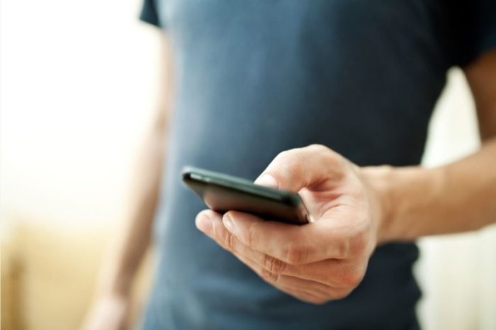 Najlepszy smartfon – Na co zwrócić uwagę przy zakupie mężczyzna trzymający smartfon